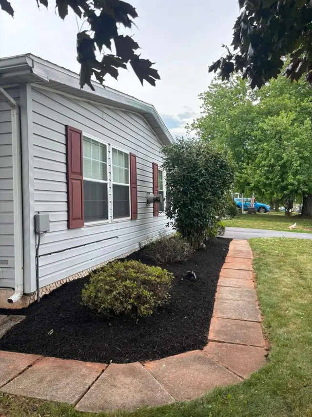 Side garden beds after cleanup, edging, and fresh mulch